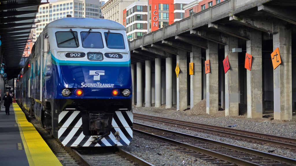 Blue and white train with black and white stripes on the front.