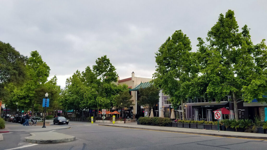 Green tree lined downtown street in a small town.