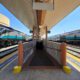 Black, silver, and teal painted trains waiting at a station platform.
