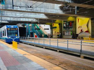 Blue and white light rail train entering the station.