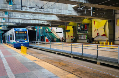 Blue and white light rail train entering the station.